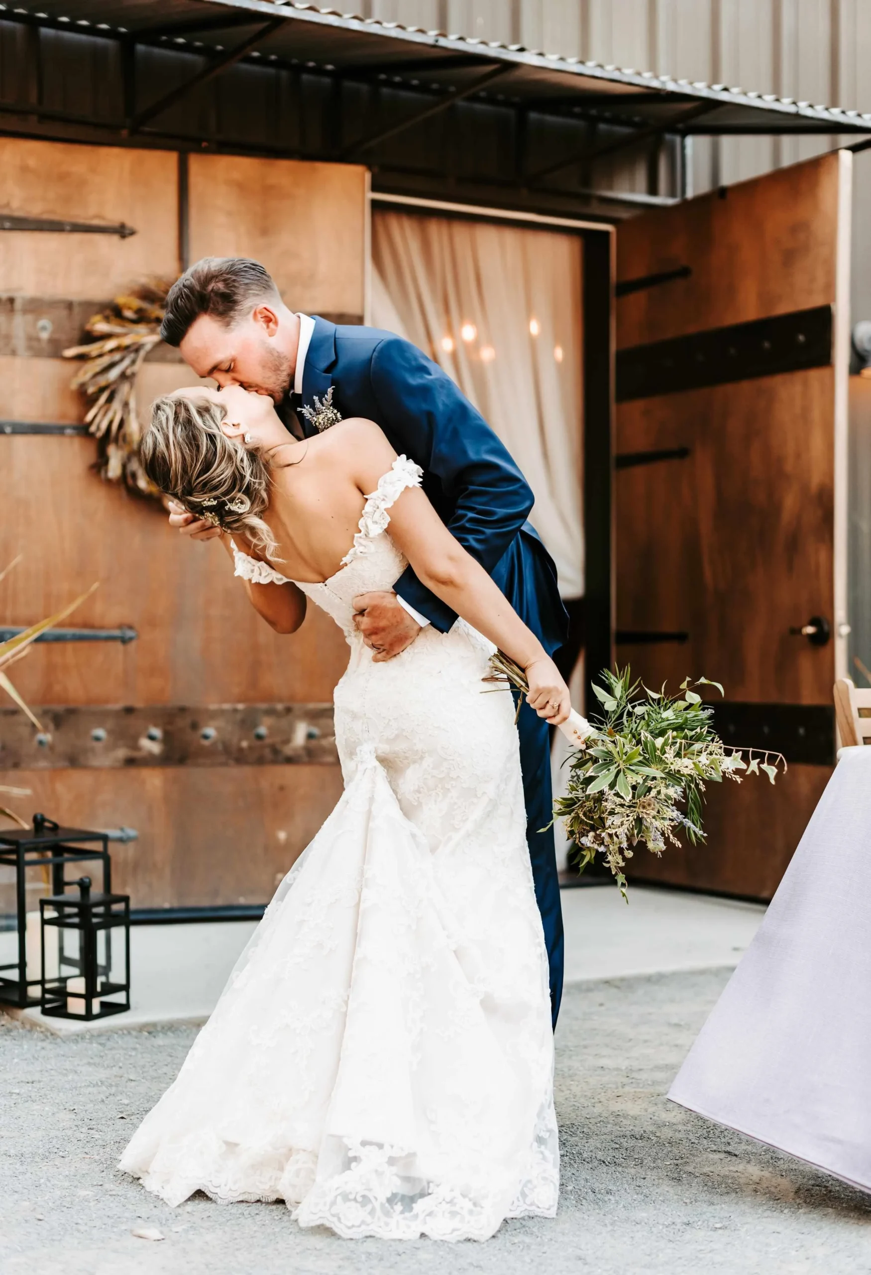 Bride and Groom kiss in front of barn doors