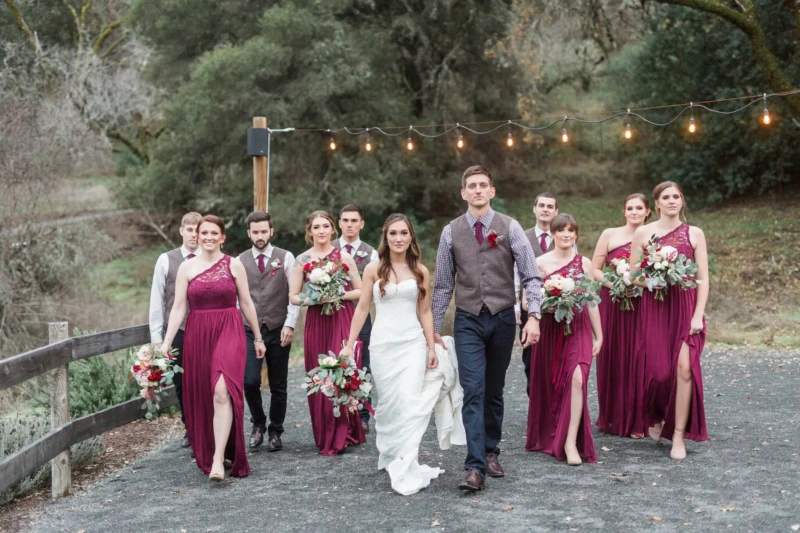 Bride And Groom Posing with Bridesmaids And Groomsmen Carrying Flowers In Hands